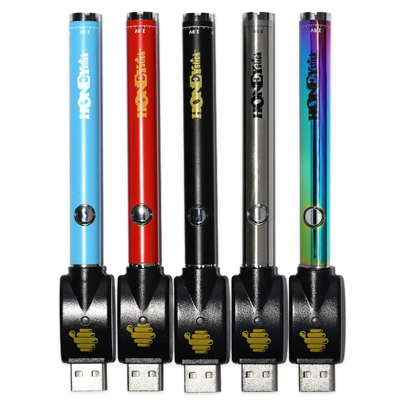 Honeystick's 510 threaded vape cartridge batteries. Shown in various colours, silver, rainbow, red, black, and blue. Flipped upside down with their usb charger attached.
