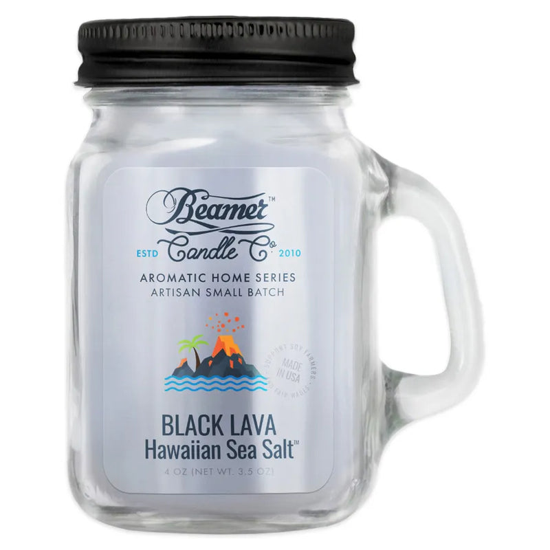 Beamer Candle Co's 4oz candle in a Black Lava Hawaiian Sea Salt Scent. Gray wax, reusable glass mason jar with metal lid. The Beamer branded sticker features an exploding volcano next to a tree over the an ocean.