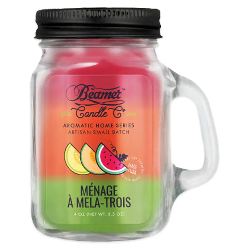 Beamer Candle Co's 4oz candle in a Menage a Mela Trois scent. Green, red, and orange wax, reusable glass mason jar with metal lid. The Beamer branded sticker features a cantaloupe, honeydew, and watermelon slice.