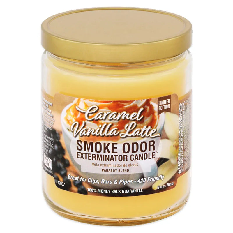 Smoke Odor's 13oz Exterminator Candle in a Caramel Vanilla Latte scent. A pastel muted yellow wax colour. The sticker label has a latte in a white mug with whip cream on top and caramel drizzle. Vanilla leaf and beans on the left and right side of the mug.