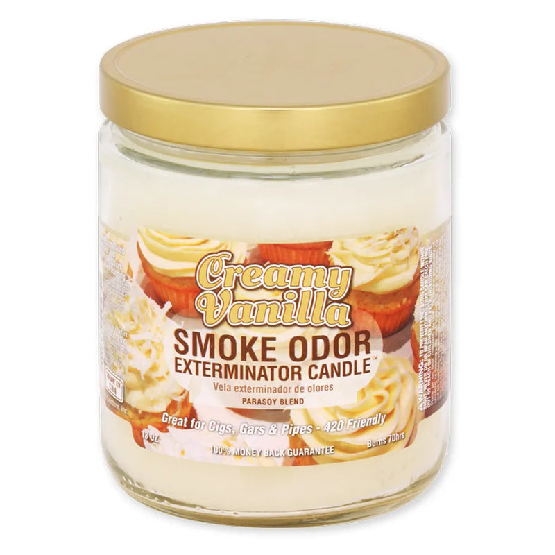 Smoke Odor's 13oz Jar Candle in a Creamy Vanilla scent. A off-white wax colour, gold lid, glass jar, and Smoke Odor Exterminator branded sticker branding with vanilla cupcakes.