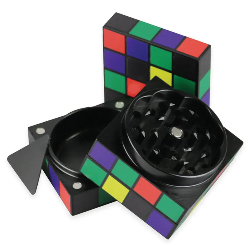A 4 piece herb grinder in the shape of a classic cube toy. Open and showcasing 3 separate pieces and a kief scraper.