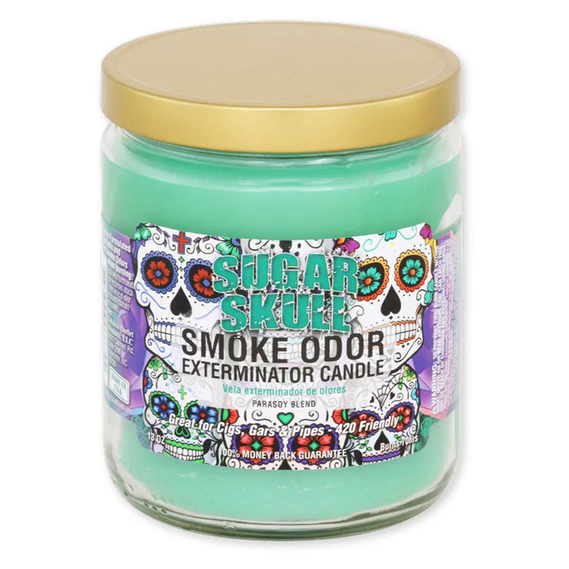 Smoke Odor's 13oz Exterminator Candle in the Sugar Skull scent. A turquoise wax colour with a gold lid. The sticker label features various traditional sugar skulls in different colours and accents.
